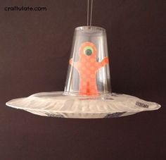 a paper plate alien spaceship craft hanging from a ceiling with the words paper plate alien spaceship craft on it