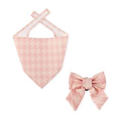 a pink and white bib with a bow on the front is next to a baby bib