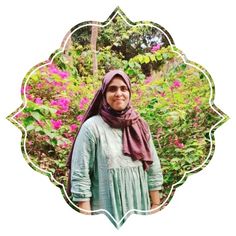 a woman wearing a headscarf standing in front of flowers