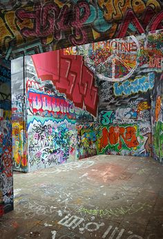 an empty room with graffiti all over the walls