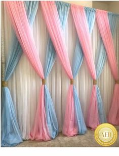 an image of curtains with pink, blue and white drapes on the wall behind them