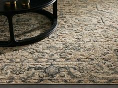 a large rug with an ornate design on the floor in front of a coffee table