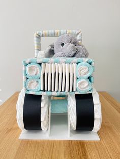 a teddy bear is sitting in the back of a toy truck made out of diapers