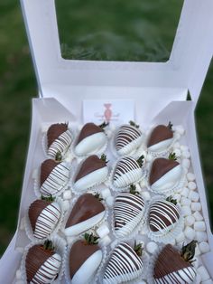 a box filled with chocolate covered strawberries on top of a green grass covered field