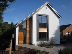 a small white house with wooden doors and windows