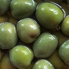 some green olives are in a pile together