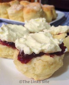 scones filled with cream and jelly sitting on a plate