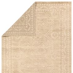 a beige rug with an intricate design on the top and bottom corner, in front of a white background