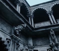 an elephant statue on the side of a building with arches and pillars in front of it