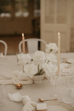 the table is set with white flowers and candles