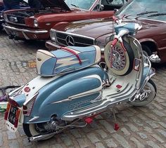 a motorcycle parked next to other cars in a parking lot