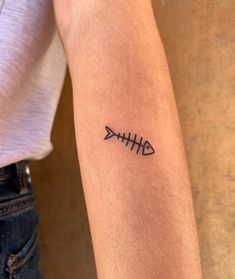 a person with a fishbone tattoo on their arm