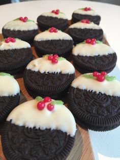 chocolate cookies decorated with white frosting and cherries on a wooden platter, ready to be eaten