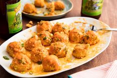 some food is on a white plate and next to a bottle of boozepie