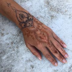 a henna tattoo on someone's left hand