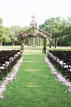 an image of a wedding ceremony with flowers on the aisle and chairs lined up in rows