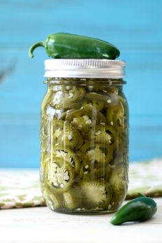 pickles in a jar with a green pepper on top