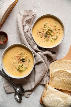 two bowls of soup with bread on the side