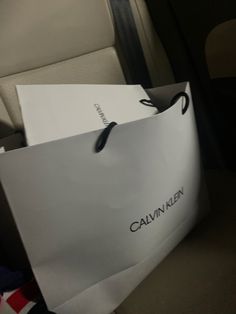 a white paper bag sitting on top of a seat next to a car headrest