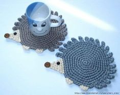 two crocheted hedgehog coasters sitting next to each other with a coffee cup in the middle