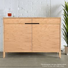 a wooden cabinet sitting next to a potted plant