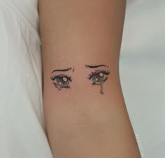 a woman's arm with an eye tattoo on the left side of her body