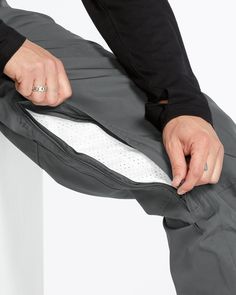 a person is holding their pants open and showing the side pockets on his pants that are closed