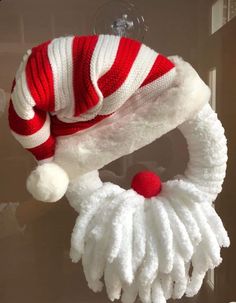 a red and white knitted hat hanging from a hook