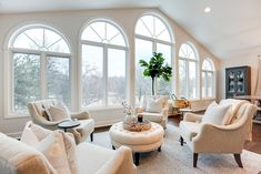 a living room filled with furniture and large windows