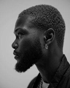 a close up of a person wearing a shirt and tie with earring in his ears