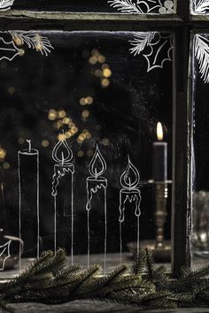 candles are lit in front of a frosted window