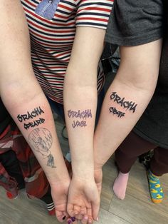 two people with matching tattoos on their arms