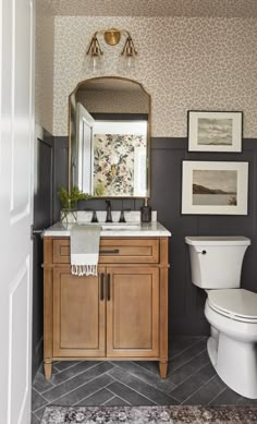 a bathroom with a toilet, sink and mirror in it's centerpieces