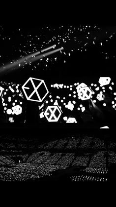 a black and white photo of some lights in the dark with an abstract background that looks like hexagonal shapes