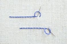 two knitting needles with blue yarn on them