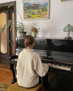 a woman is playing the piano in her living room