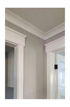 an empty bathroom with white cabinets and gray walls