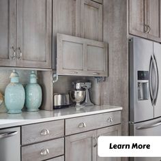 a kitchen with gray cabinets and silver appliances