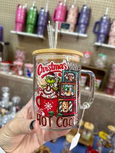 a person holding up a coffee mug with christmas movies on it