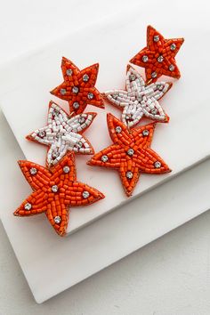 Color: Orange, White Style: Dangle Star Shaped Beaded Detail Rhinestone Detail Gold Threaded Trim Felt Backing 3.5" Drop Launched: 8/8/24 Beaded Earrings On Felt, Beaded Star, Earring Inspiration, Beaded Earring, Graphic Dress, Earrings Inspiration, Mini Short, Custom Graphics, Basic Dress