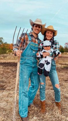 a man, woman and child are posing for a photo in the field with their farm equipment