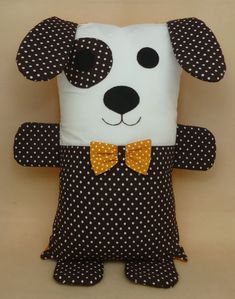 a stuffed dog with a bow tie on it's head and polka dot fabric