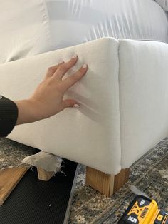 someone is working on an upholstered couch