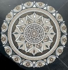 an intricate design on the side of a black and white table top with gold accents