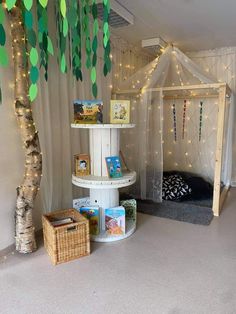 there is a bed and some books on the floor in this room with lights strung from the ceiling