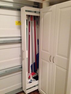 an open closet with baseball bats in it