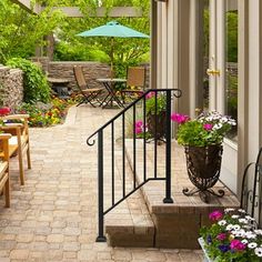 a patio with chairs, tables and an umbrella over the door to another room that has flowers in it