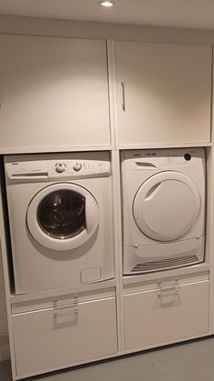 the washer and dryer are lined up against the wall in this laundry room