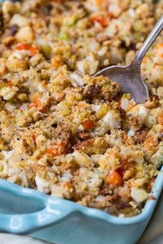 a blue casserole dish filled with stuffing and vegetables