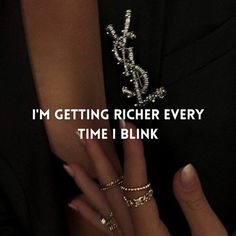 a woman's hand with two rings on it and the words i'm getting richer every time i blink